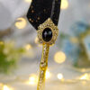 Beautifully ornate vintage golden centerpiece holding a deep jet black jewel