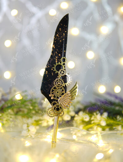 Close-up of metal steampunk gears and gold wing on black feather