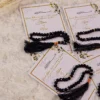Close-up of black prayer beads on Nikkah favour card