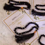 Multiple black tasbeeh favour cards with gold borders