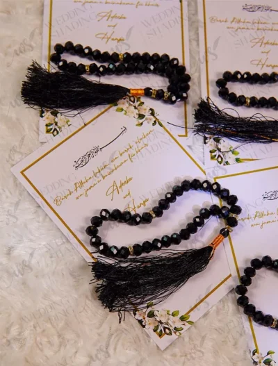 Multiple black tasbeeh favour cards with gold borders