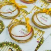 Vibrant Mayun favour cards featuring couple under floral canopy
