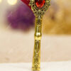 Beautiful gold speckled burgundy feather on a textured antique gold handle