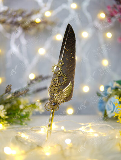 Sleek polished gold handle beneath a gold-speckled dark feather
