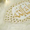 Close-up of intricate gold embroidery and sparkling stonework border on white velvet Imam Zamin
