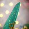 Vibrantly colored rich emerald green feather covered in golden specks