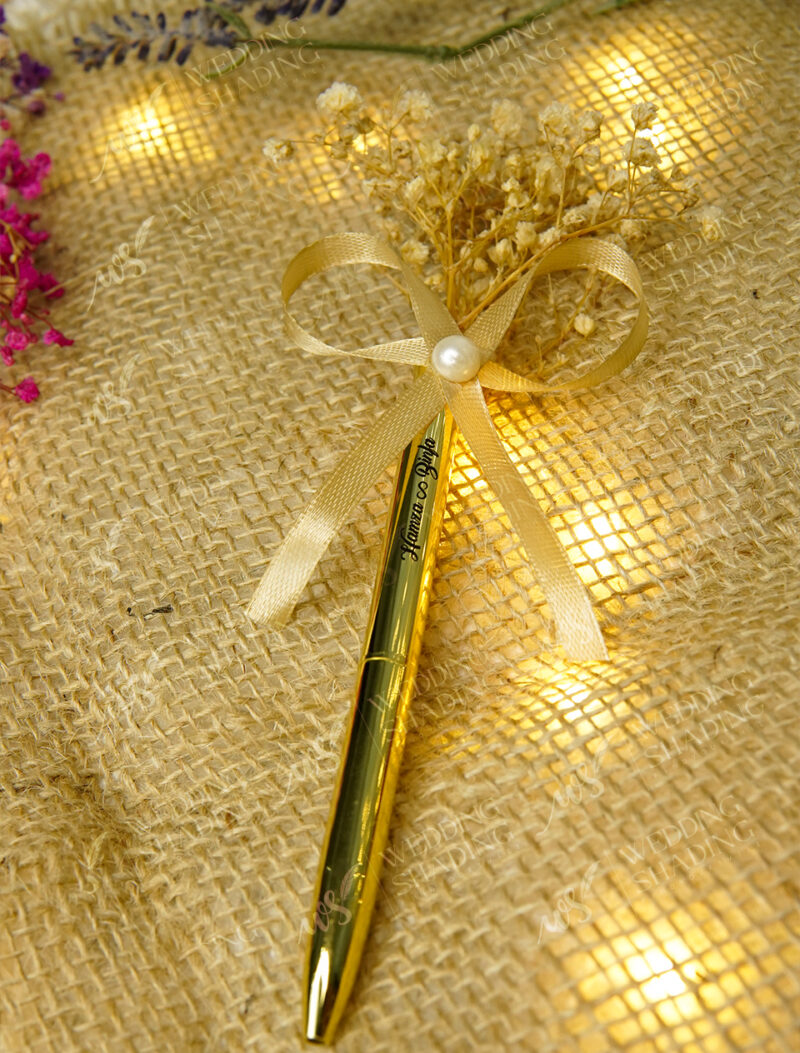 Sheer golden ribbon bow showcasing a perfectly placed center pearl