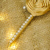 Elegant pearl beaded handle wrapped in shiny golden satin ribbon
