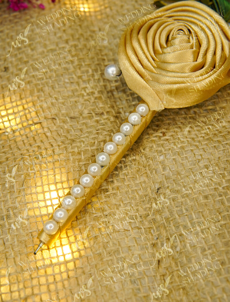 Elegant pearl beaded handle wrapped in shiny golden satin ribbon
