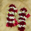 Close-up of deep red velvet roses and delicate white floral details on bridal gajray