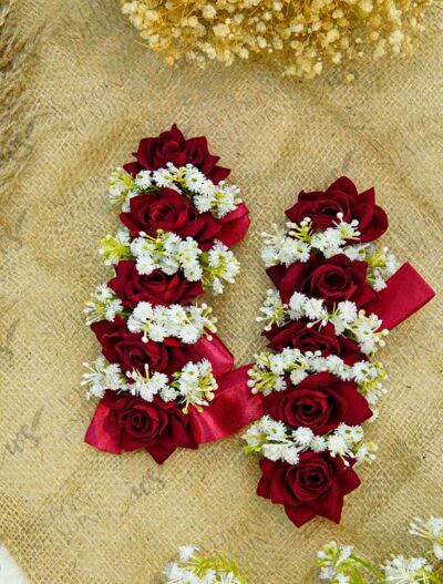 Close-up of deep red velvet roses and delicate white floral details on bridal gajray