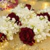 Close-up of deep red artificial roses and delicate white floral details on bridal gajray