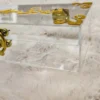 Detailed view of shiny gold clasp on transparent wedding box