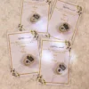 Premium white and gold favour cards featuring pearl tally rings