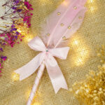 Full view of the soft pink feather studded with bright rhinestones