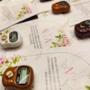 Assorted colorful tally counters on personalized Islamic wedding favour cards