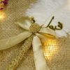 Golden satin bow centered with a textured golden focal bead