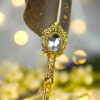 Intricately detailed golden vintage centerpiece framing a diamond crystal