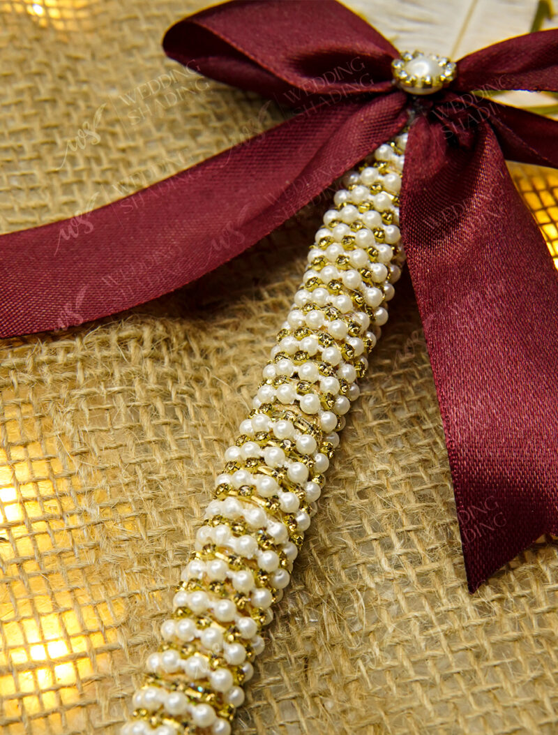 Stunning gold acrylic Qubool Hai calligraphy above a deep burgundy bow