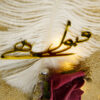 Small pearl accents and golden adornments highlighting the romantic rose