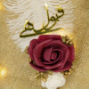 Deep red burgundy folded fabric rose and precise golden calligraphy
