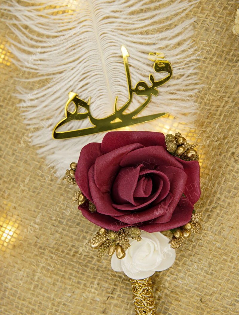 Deep red burgundy folded fabric rose and precise golden calligraphy