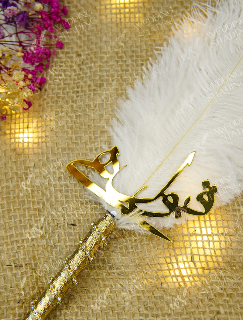 Beautiful golden Qubool Hai calligraphy piece resting on white feather