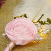 Close-up of golden Qubool Hai calligraphy and beautiful pink rose