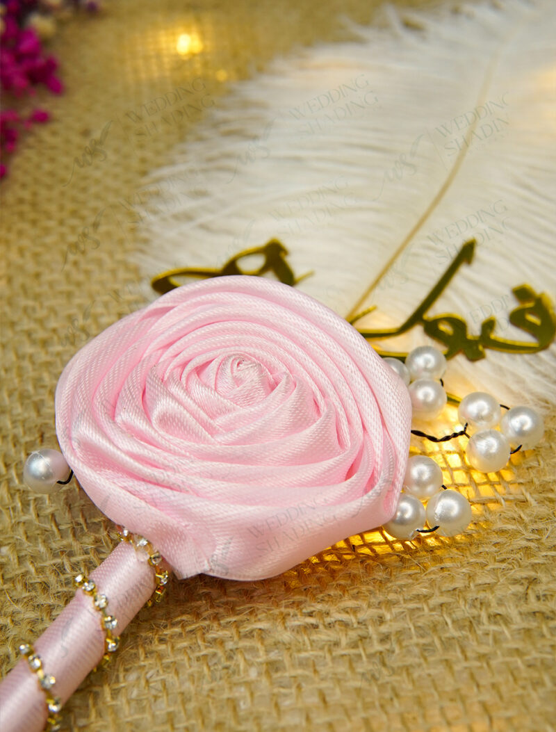 Close-up of golden Qubool Hai calligraphy and beautiful pink rose