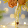 Beautiful small yellow folded satin roses at the base of the feather