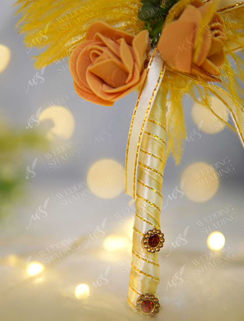 Beautiful small yellow folded satin roses at the base of the feather