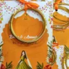 Gold glass bangles tied to vibrant Mehndi favour cards