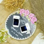 Overhead view of round mirror ring tray with pink roses and custom white text