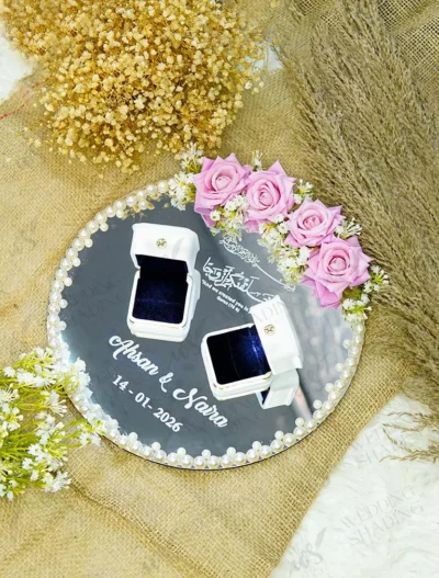 Overhead view of round mirror ring tray with pink roses and custom white text