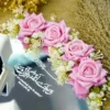 Close-up of pink silk roses and Quranic verse on mirror ring tray
