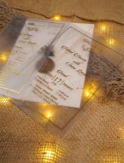 Frosted vellum wedding invitation with gold wax seal and translucent wrap