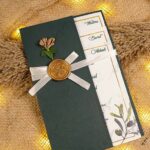 Close-up of olive branch watercolor design on cream wedding card