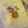 Close-up of real dried purple flowers on wedding invitation