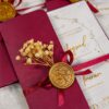 Close-up of gold foil calligraphy on cream card inside maroon envelope