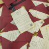 Close-up of gold floral wax seal on deep maroon textured envelope