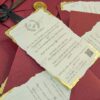 Multiple maroon wedding invitations arranged with wax seals visible