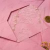 Clear acrylic wedding invitation card with floral arch design on pink envelope