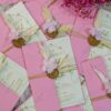 Detail view of gold wax seal and feather on soft pink wedding card