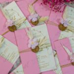 Detail view of gold wax seal and feather on soft pink wedding card