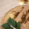 Close-up of engraved rings and verse on natural wood grain surface
