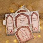 Multi-fold Mughal arch wedding invitation with red and gold panels