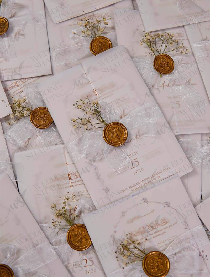 White wedding card with organza ribbon bow, wax seal, and dried flowers