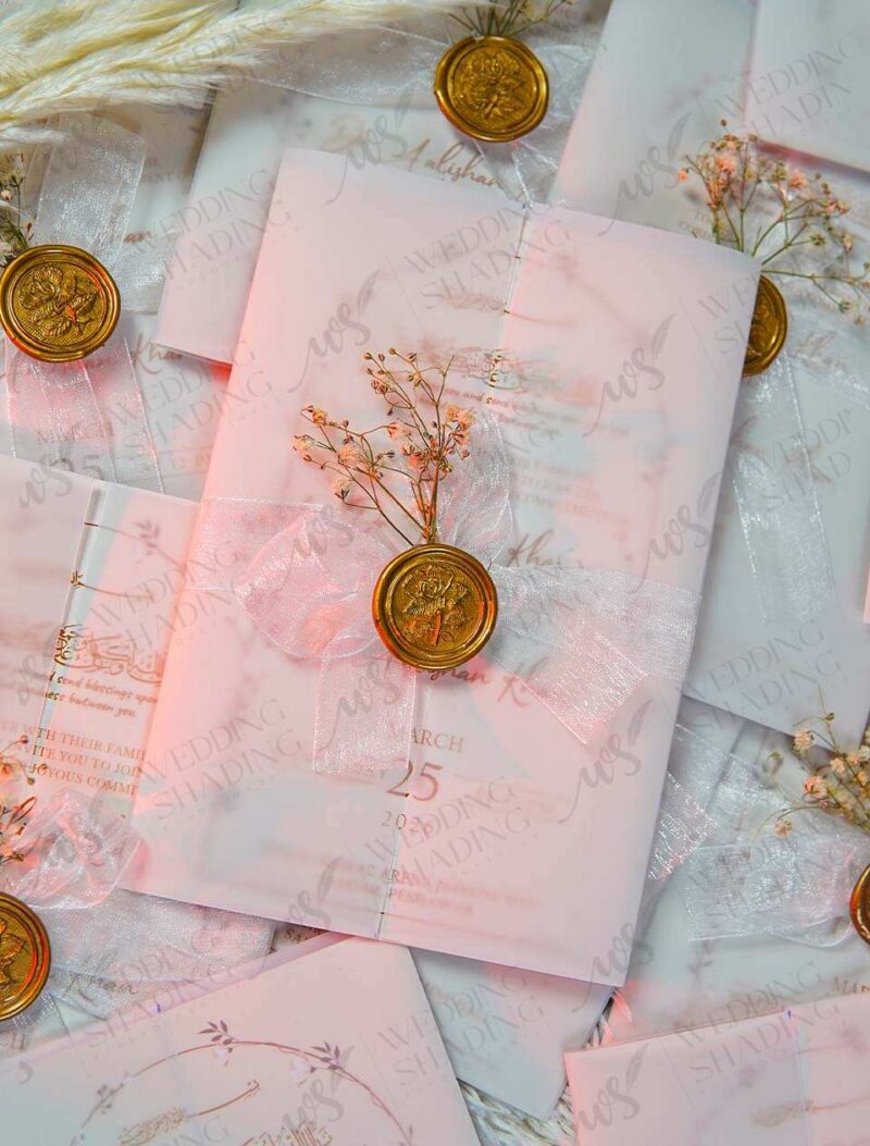 Close-up of gold floral wax seal on white translucent vellum wrap
